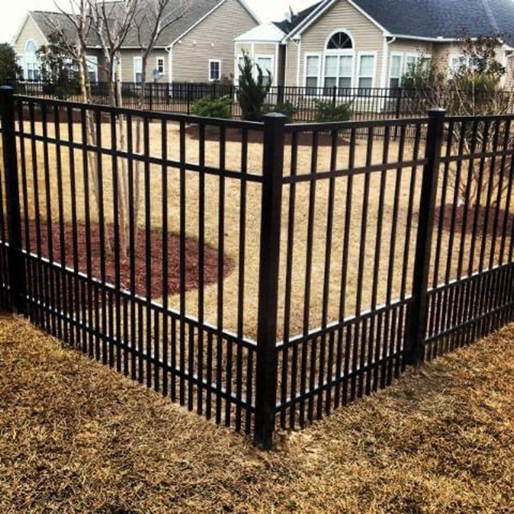 A wooden cross-buck style fence with wire mesh backing running along a wooded property line.